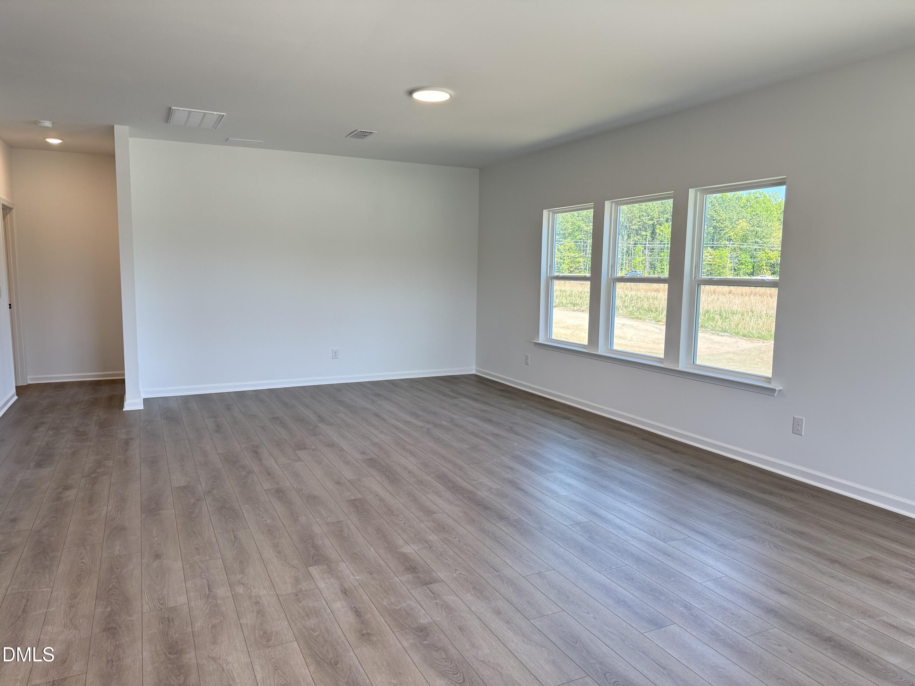 433 Contempo Court, Unit 3 Rolesville, NC 27571 - Photo 10 of 40 an empty room with wooden floor and windows