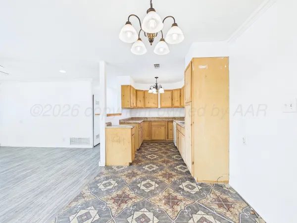 a view of a kitchen with a fridge and a wooden floor