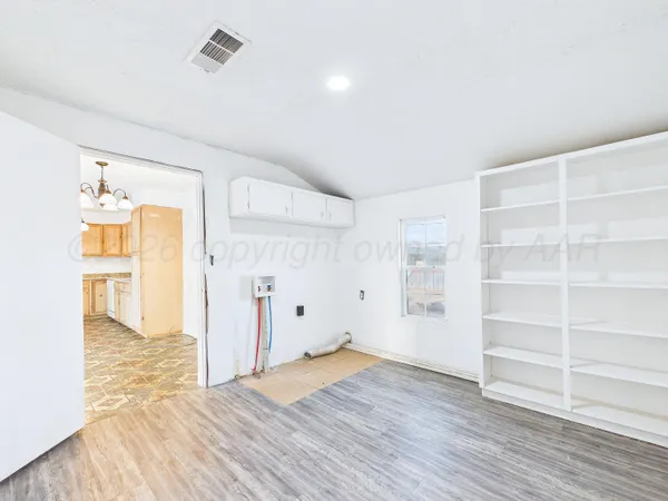 a view of empty room with wooden floor