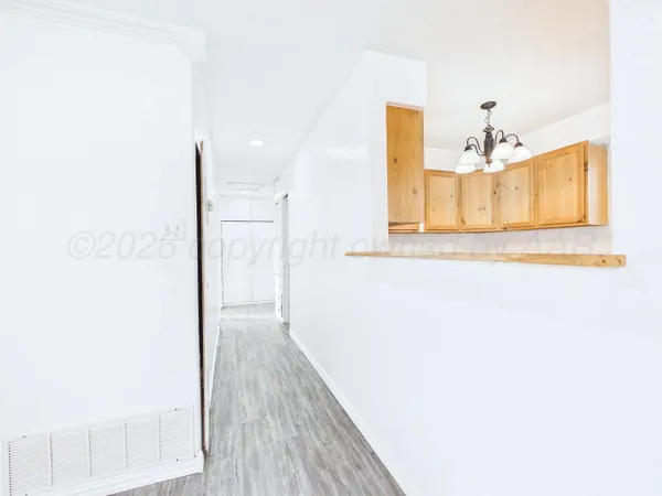 a view of a hallway with wooden floor