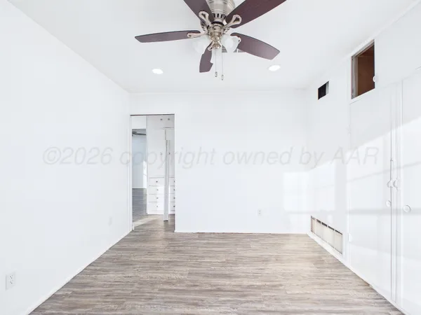 a view of empty room with wooden floor