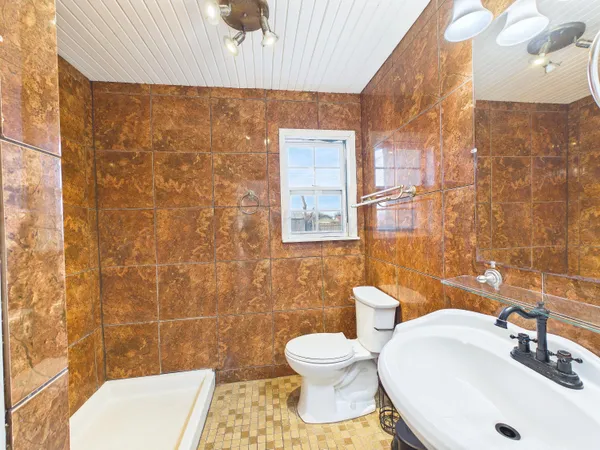 a bathroom with a sink a toilet and a mirror