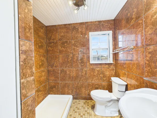 a bathroom with a toilet and a shower