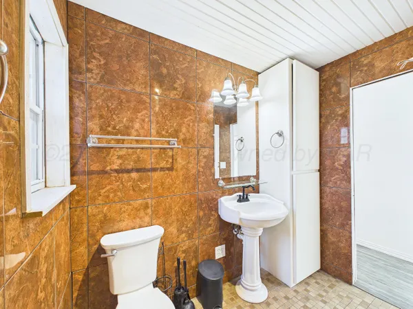 a bathroom with a toilet sink and mirror