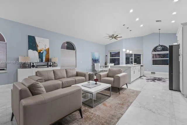 a living room with furniture and view of kitchen
