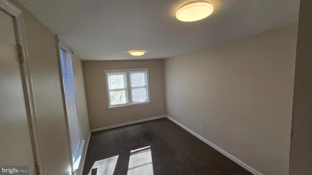 an empty room with windows and mirror