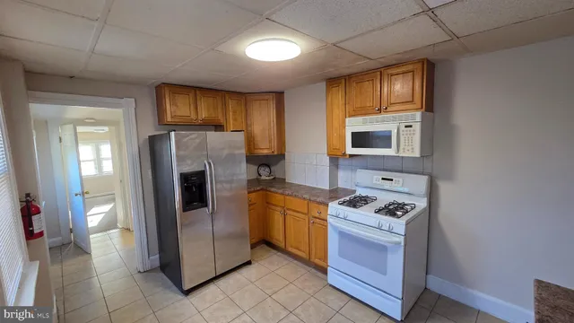 a kitchen with stainless steel appliances granite countertop a refrigerator and a stove
