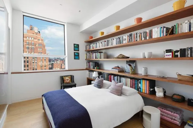 a bedroom with furniture and a book shelf