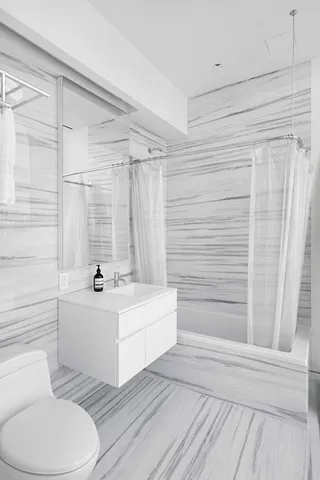 a bathroom with a sink a toilet a mirror and bathtub