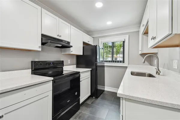 a kitchen with granite countertop a stove and a sink