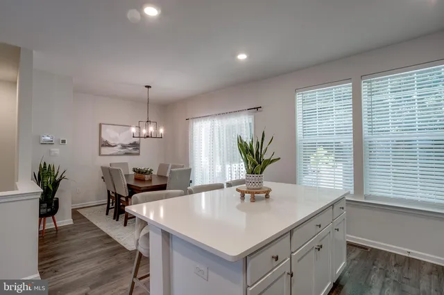 a kitchen with a table chairs and white cabinets