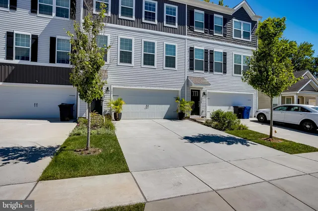 a front view of a house with a yard and trees