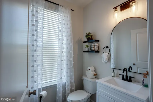 a bathroom with a toilet sink and mirror