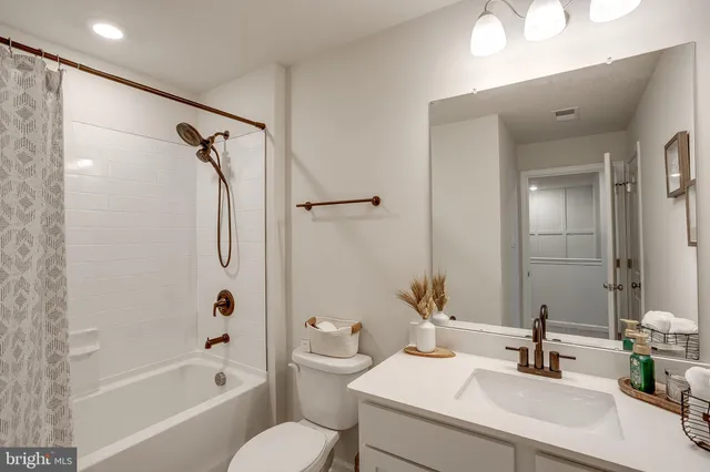 a bathroom with a sink toilet tub vanity and shower