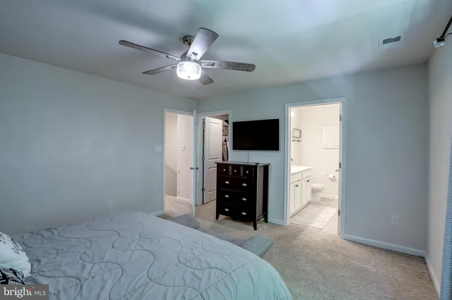 a bedroom with a bed and a flat tv screen on dresser
