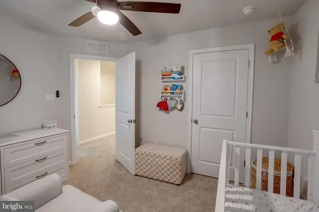 a living room with furniture and a baby crib