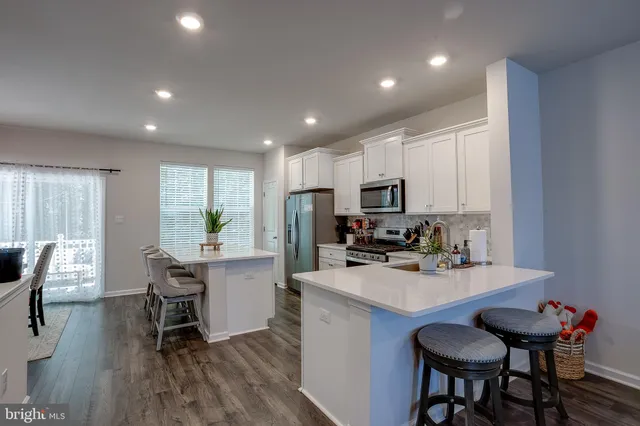 a kitchen with a table chairs refrigerator and cabinets