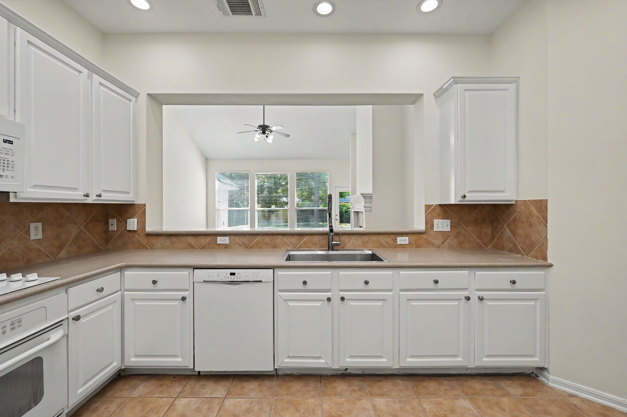14 South Rambling Ridge Place The Woodlands, TX 77385 - Photo 15 of 42 Kitchen sink overlooks the family room and backyard, allowing you to enjoy peaceful outdoor views while staying connected to family and guests.