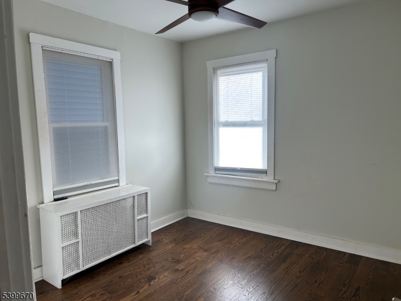 417 Valley Road Montclair, NJ 07043 - Photo 5 of 10 an empty room with wooden floor cabinet and windows