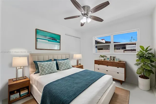 a bedroom with a bed a lamp and potted plant