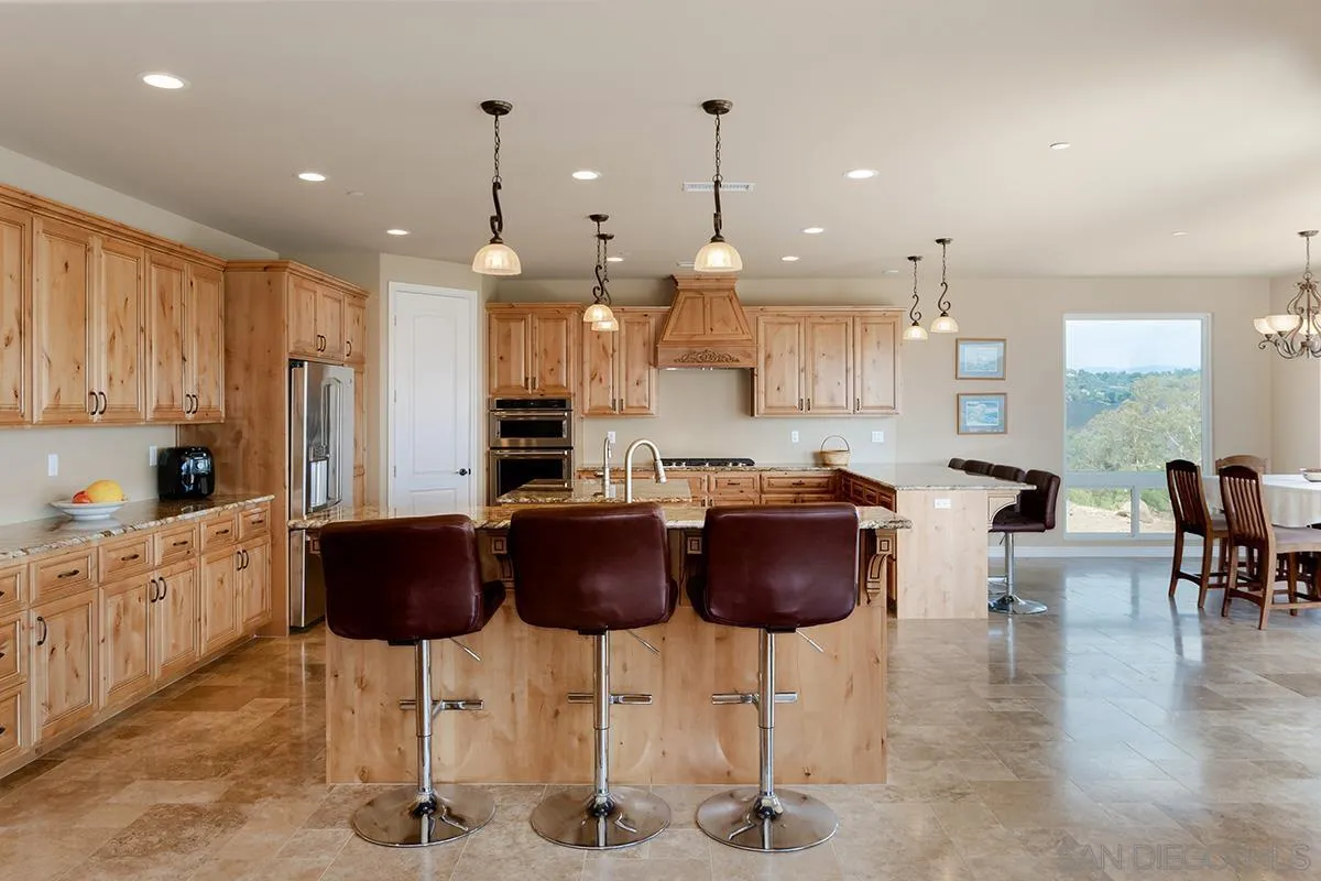 19840 7th Place Escondido, CA 92029 - Photo 15 of 49 a kitchen with stainless steel appliances kitchen island granite countertop a stove a sink and a refrigerator