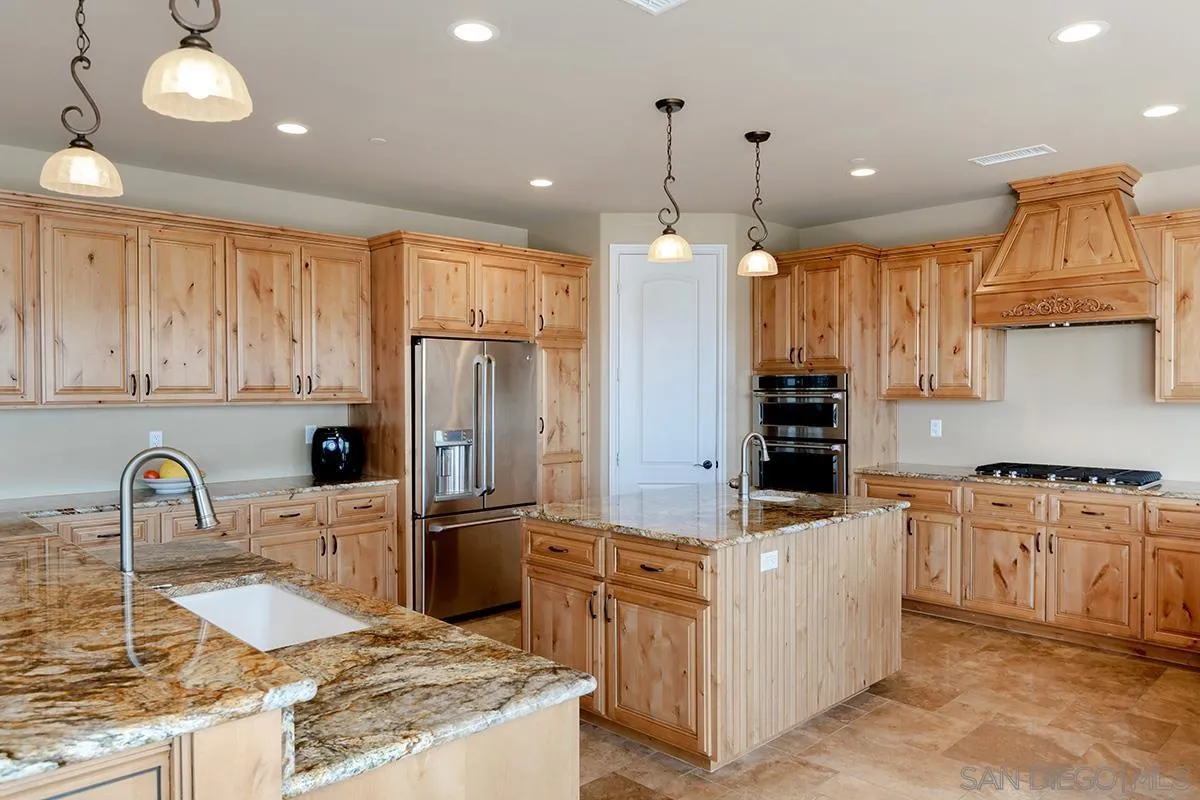 19840 7th Place Escondido, CA 92029 - Photo 17 of 49 a kitchen with stainless steel appliances granite countertop a sink stove and refrigerator