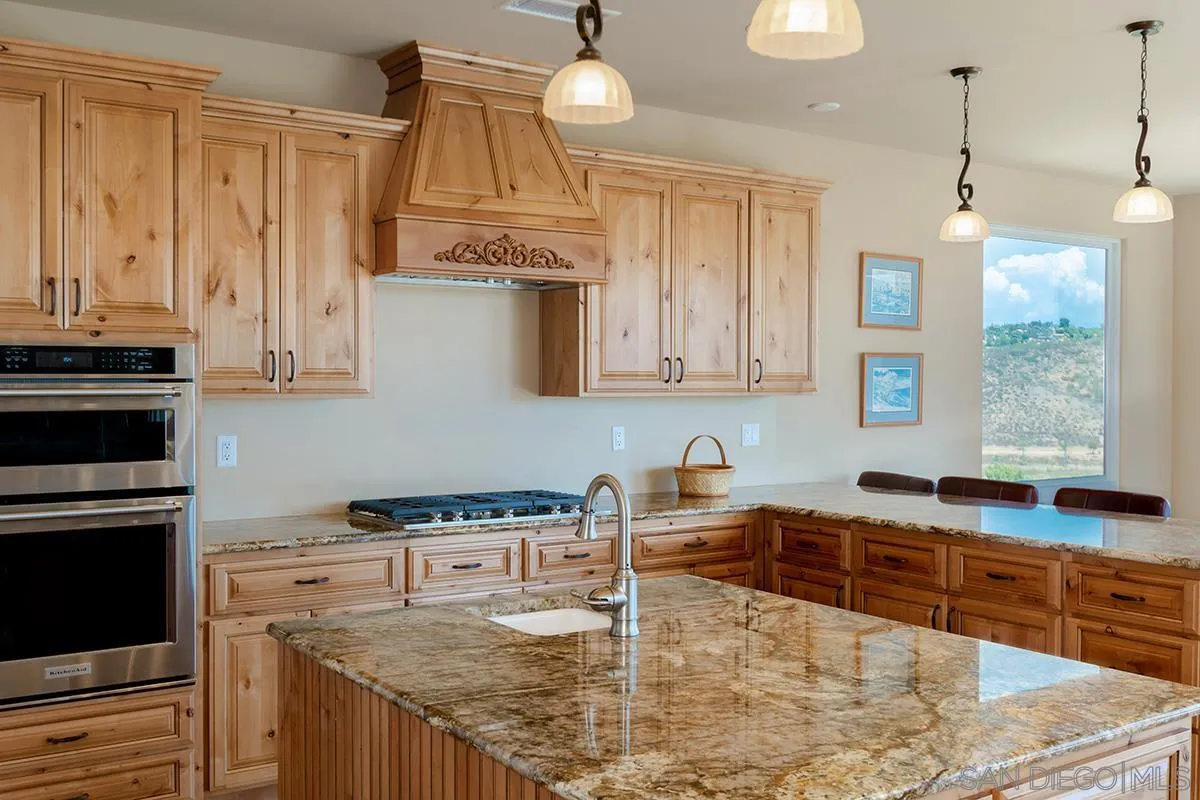 19840 7th Place Escondido, CA 92029 - Photo 20 of 49 a kitchen with stainless steel appliances granite countertop a sink a stove and a wooden cabinets
