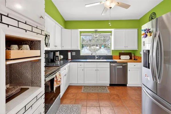 a kitchen with a sink a window stainless steel appliances and cabinets