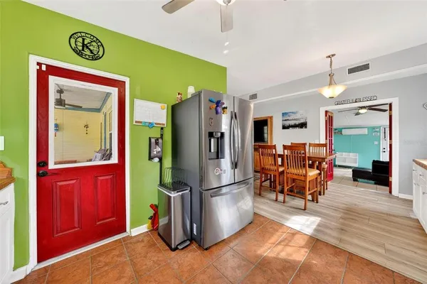 a open kitchen with stainless steel appliances granite countertop a stove a refrigerator a kitchen island a dining table and chairs with wooden floor