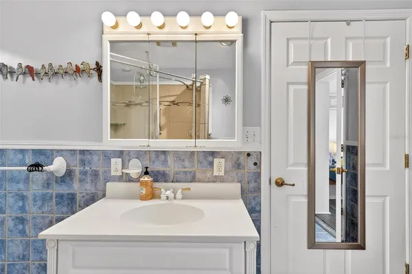 a bathroom with a double vanity sink mirror and shower