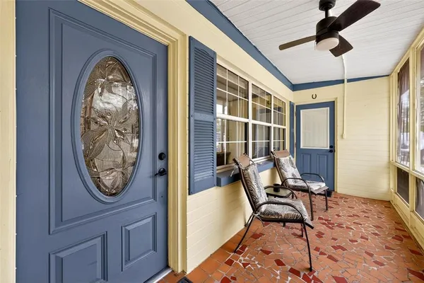 a living room with furniture a large window and wooden floor