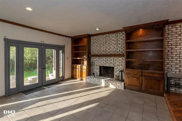 a living room with furniture a fireplace and a floor to ceiling window