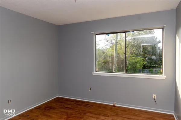 a view of a room with wooden floor and a window