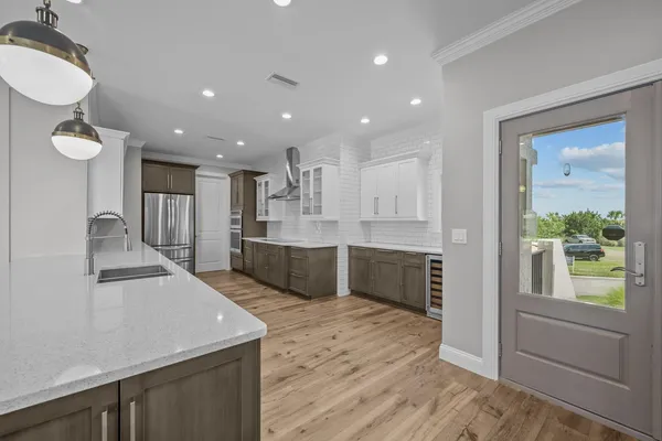 a large kitchen with stainless steel appliances granite countertop a sink and wooden cabinets