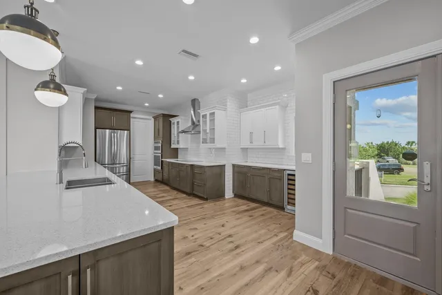 a large kitchen with stainless steel appliances granite countertop a sink and wooden cabinets