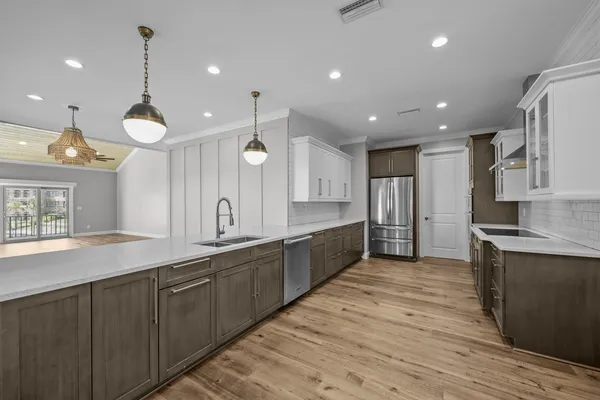 a large kitchen with stainless steel appliances granite countertop a large counter top and a wooden floors