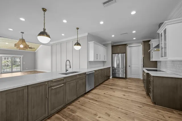 a large kitchen with stainless steel appliances granite countertop a large counter top and a wooden floors