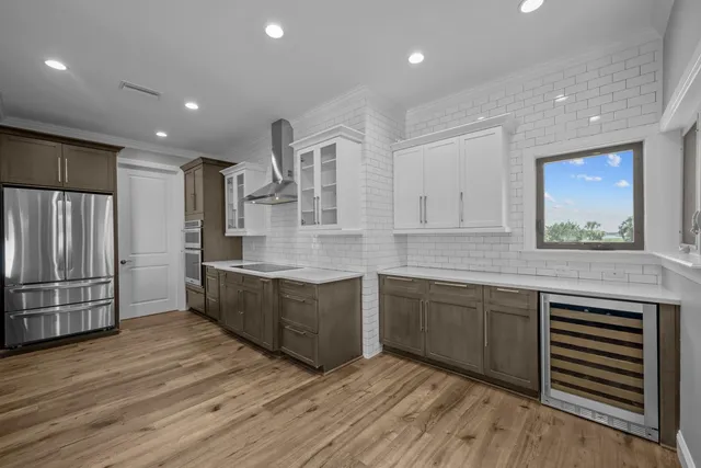 a large kitchen with stainless steel appliances granite countertop a large window a oven and a view of living room