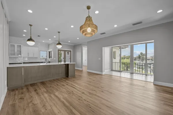 a view of a livingroom with wooden floor and a ceiling fan