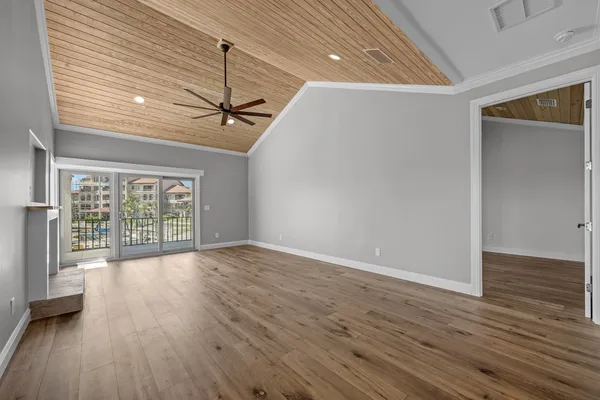 a view of a room with wooden floor and a ceiling fan