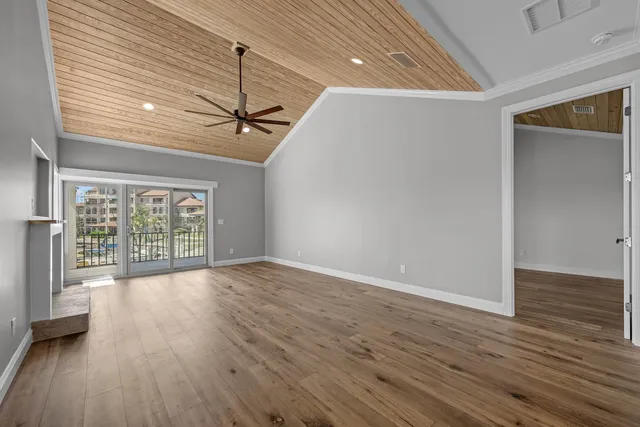 a view of a room with wooden floor and a ceiling fan