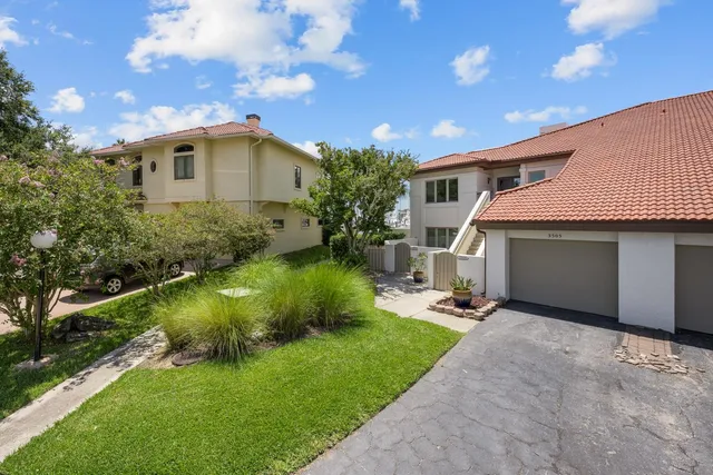 an aerial view of a house with a garden and lake view