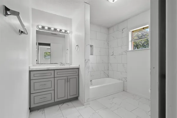 a bathroom with a bathtub sink and mirror