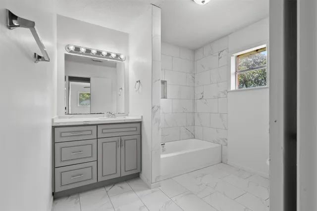 a bathroom with a bathtub sink and mirror