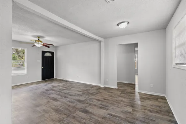 a view of an empty room with wooden floor