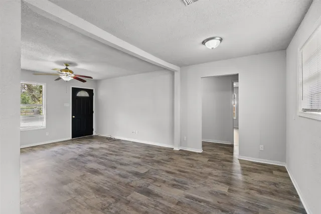 a view of an empty room with wooden floor