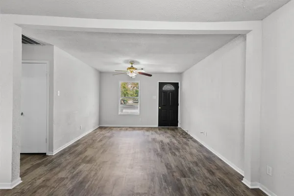 an empty room with windows and cabinet