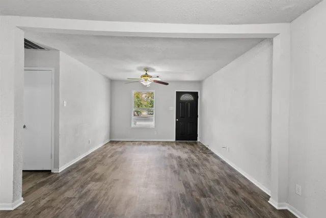 an empty room with windows and cabinet