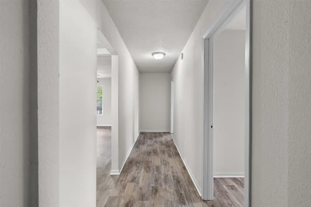 a view of a hallway with wooden floor