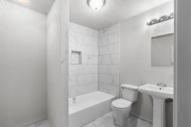 a bathroom with a sink a toilet and bathtub